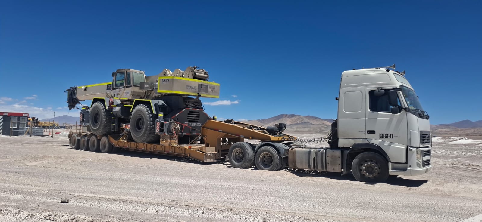 Camión SerTrans transportando grúa en la cordillera